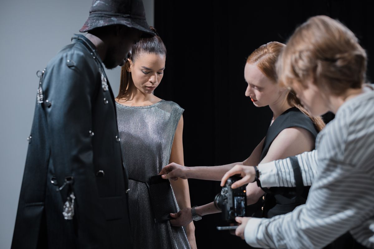 Models and designer working in a photography studio (stock photo)